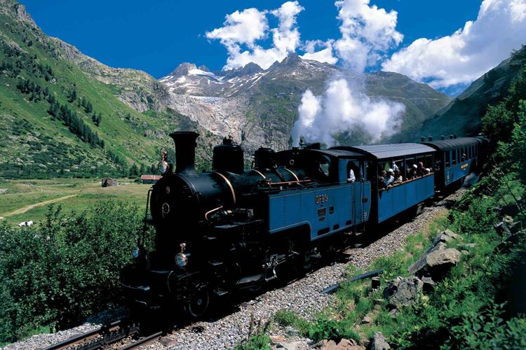 Horskými vlaky po Švýcarsku - parní souprava při sjezdu k zastávce Gletsch, v pozadí Rhonský ledovec